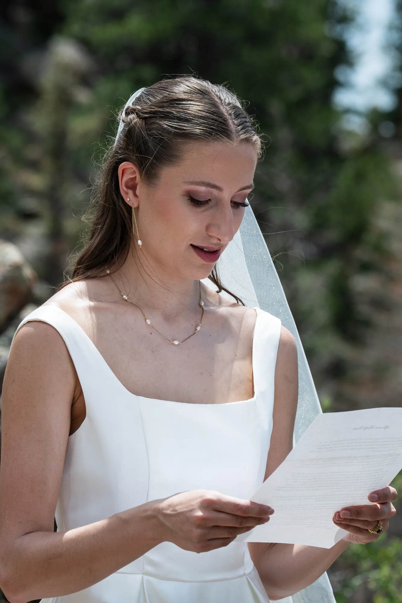 Bride reading handwritten vows during an intimate Colorado mountain elopement