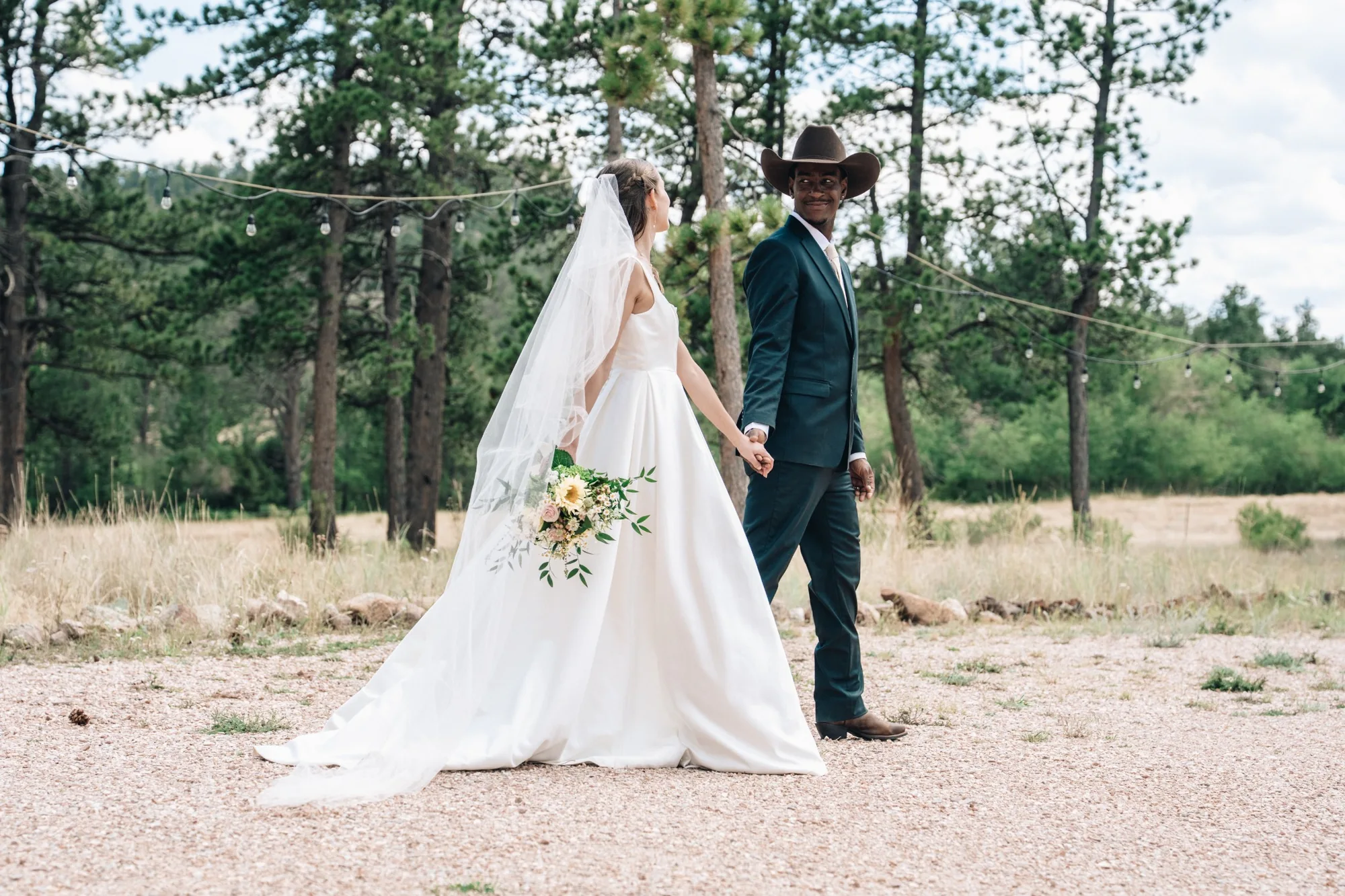Isabella and Tim walking hand in hand outside Sundance Trail Guest Ranch after their Colorado elopement