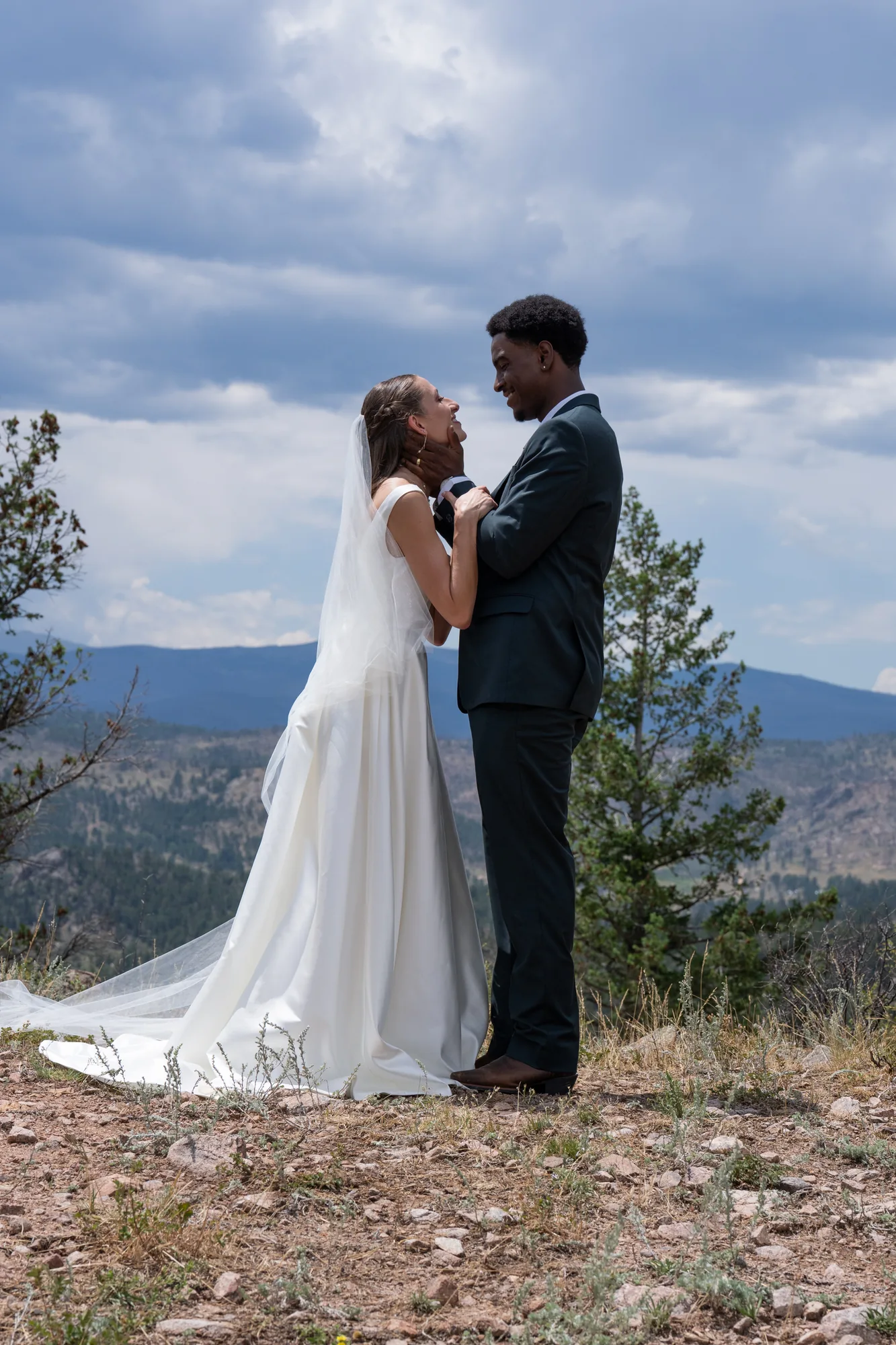 Vertical portrait of Isabella and Tim with mountain scenery behind them