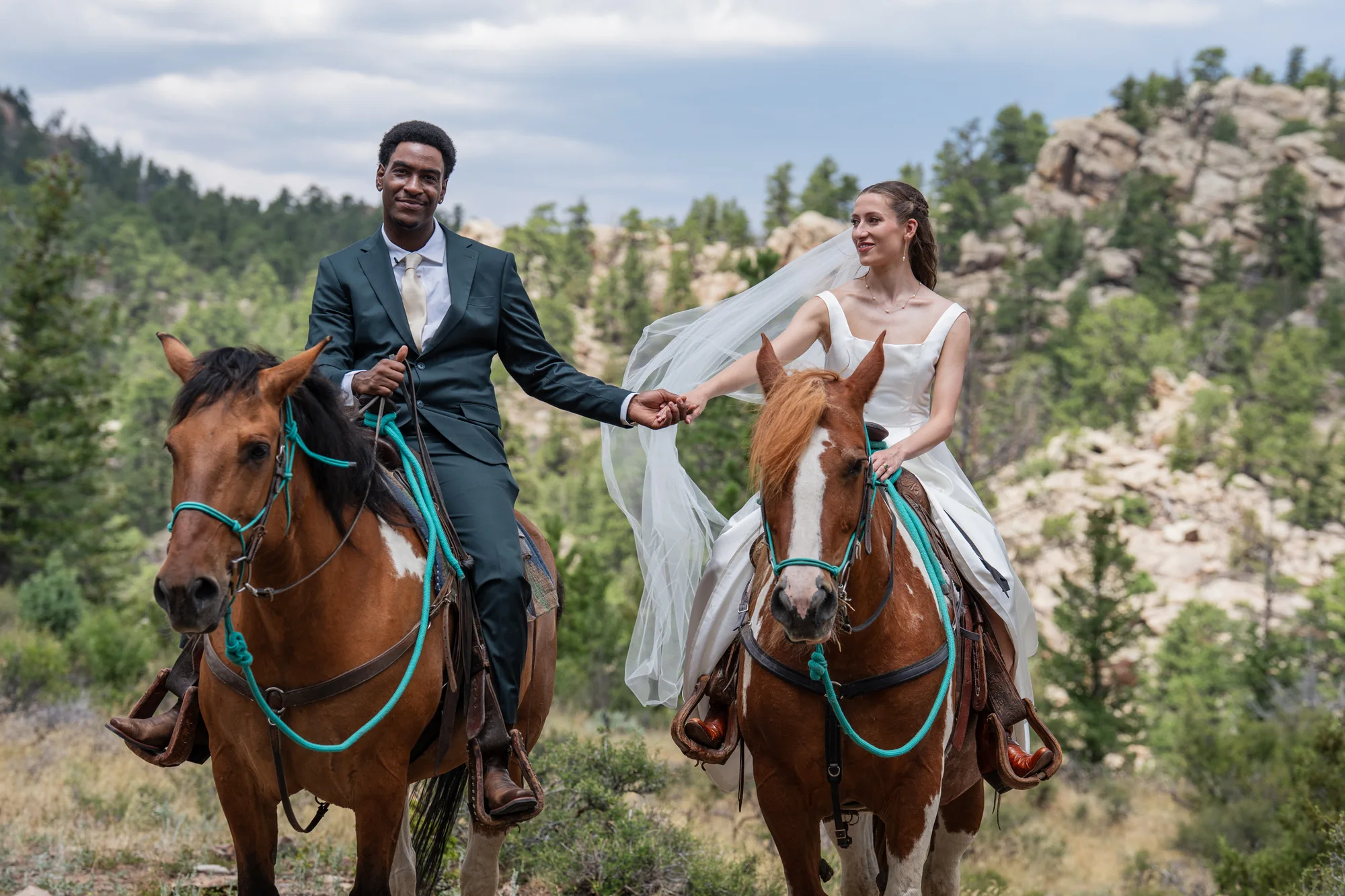 Isabella and Tim riding together during their horseback elopement at Sundance Trail Guest Ranch