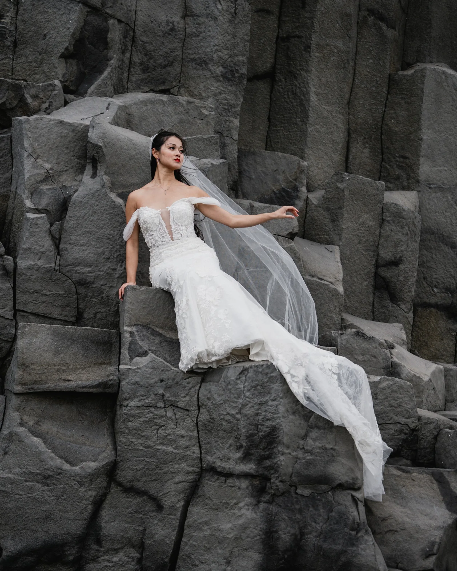 Bride posed among basalt formations near Hálsanefshellir Cave at Reynisfjara Black Sand Beach