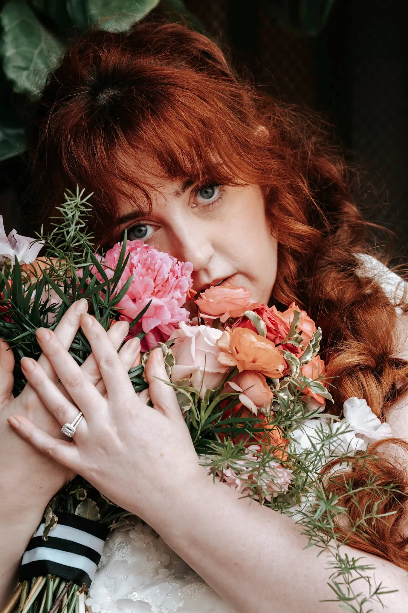 Close bridal portrait with red hair, bouquet, and visible engagement ring